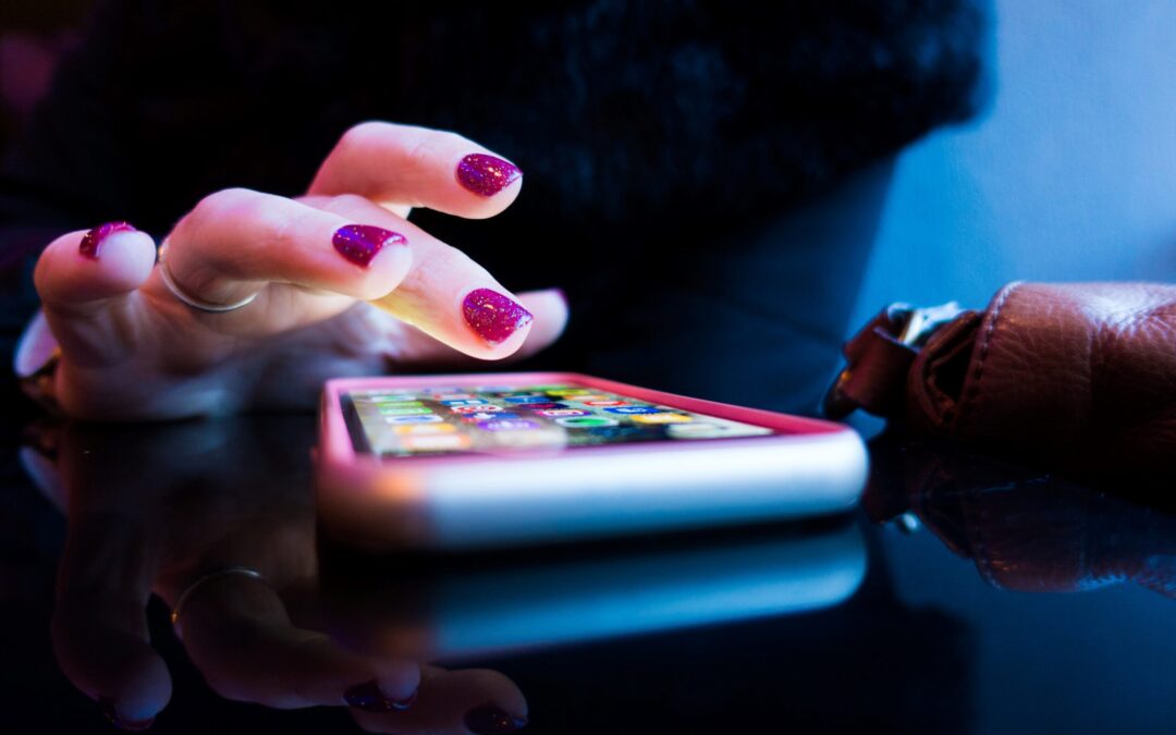 person using black smartphone with gray and pink case